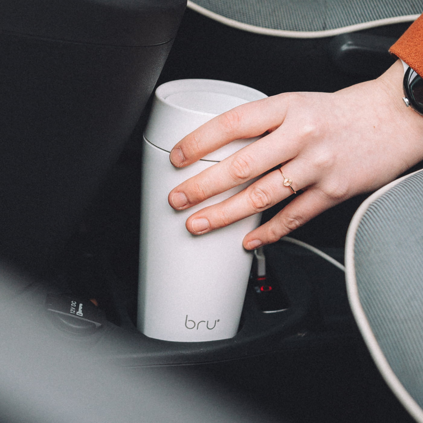 Fits every car cup block: White bru travel mug being placed into a car cup holder, showing it fits standard car cup holders
